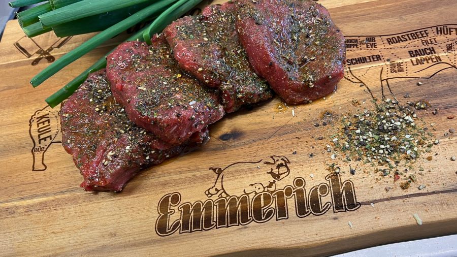 Vier frisch marinierte Fleischstücke auf einem Emmerich Holzbrettchen